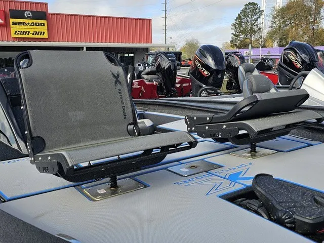 Slide: The Image of Two swivel seats on an Xpress H18C Crappie boat, with motors in the background. - 18