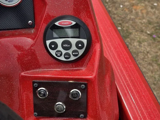 Slide: The Image of Close-up of a red boat dashboard with a round control unit and two sockets. - 17