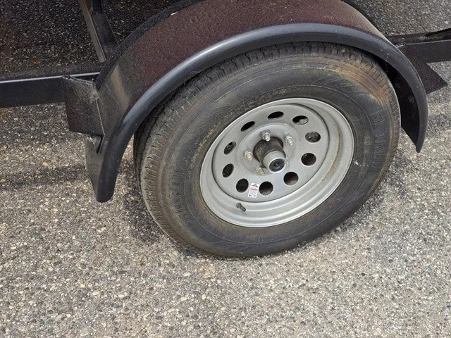 Slide: The Image of Close-up of a trailer wheel on a gravel surface. - 11