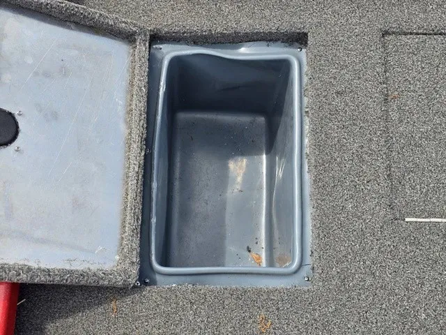 Slide: The Image of A gray storage compartment with an open lid on a boat. - 12