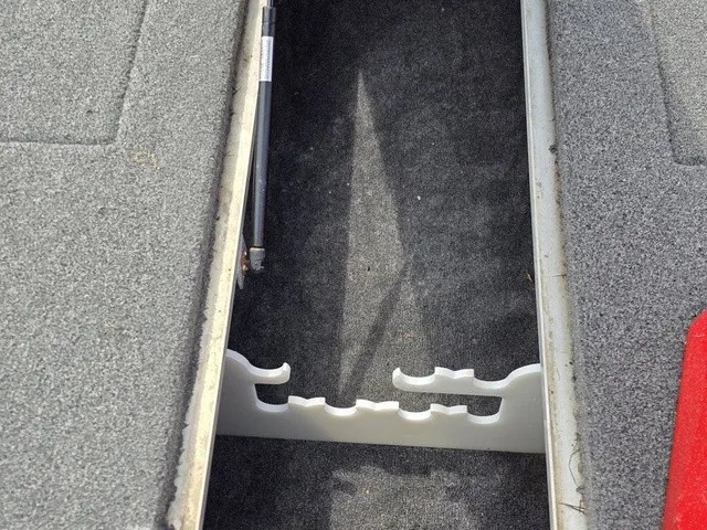 Slide: The Image of An open storage compartment with carpeted interior and rod holders. - 22