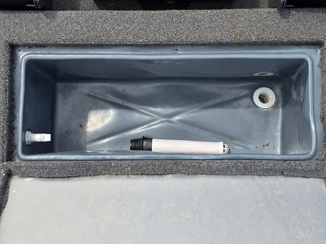Slide: The Image of A gray rectangular compartment with a drain and a hose inside. - 13