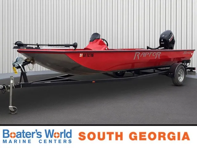 The Image of A red 2021 Caravelle Raptor 200 boat on a trailer, parked in front of a building. - 1