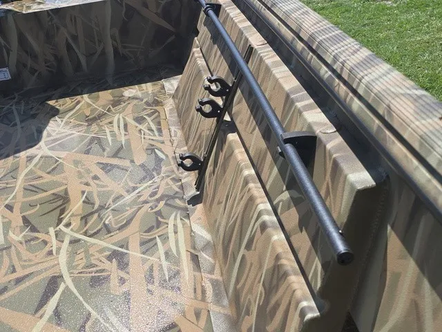 Slide: The Image of The image shows the interior of a 2025 Lowe RX1760 boat with a camouflage pattern. - 32