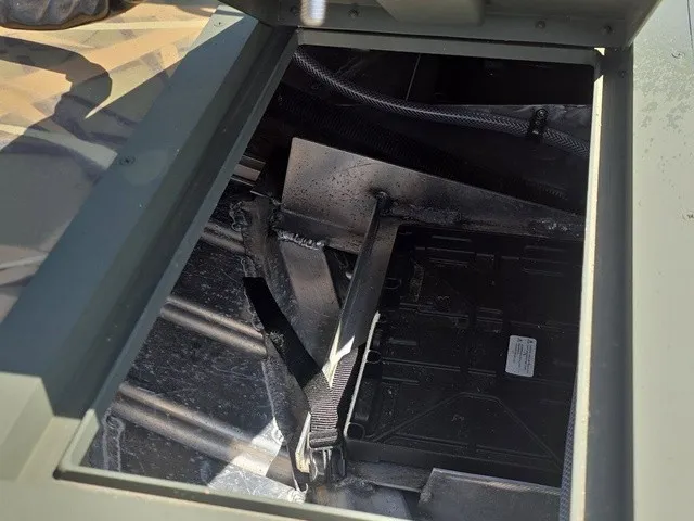 Slide: The Image of An open storage compartment in the boat reveals straps and metal structures. - 16