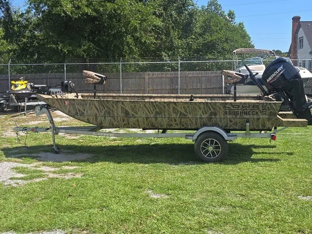 Slide: The Image of The image shows a 2025 Lowe RX1760 boat on a trailer, surrounded by grass. - 9