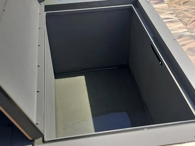 Slide: The Image of An open storage compartment on a 2025 Lowe RX1760 boat. - 17