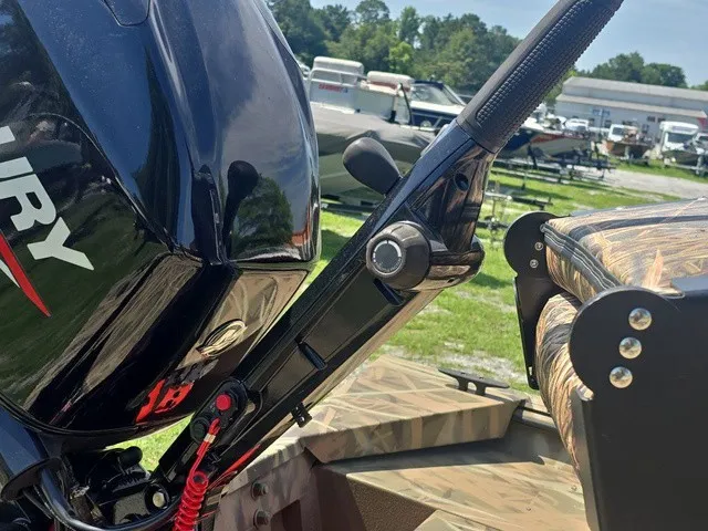 Slide: The Image of Close-up of a boat's outboard motor with throttle lever and camo-patterned seat. - 23