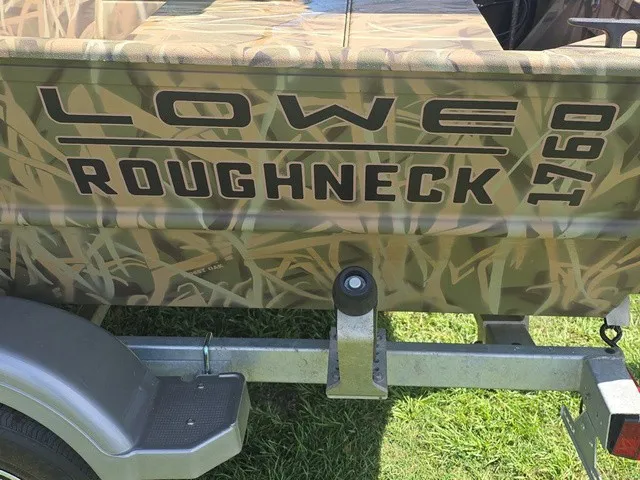 Slide: The Image of A Lowe Roughneck 1760 boat with camouflage pattern on a trailer. - 10