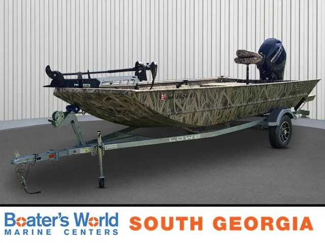 The Image of A 2025 Lowe RX1760 boat on a trailer, parked in front of a building. - 1