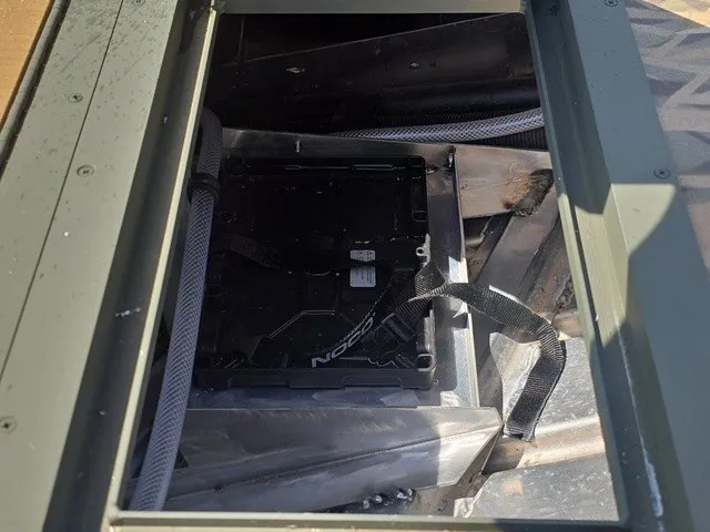 Slide: The Image of An open compartment in the boat reveals a NOCO battery box with cables. - 18