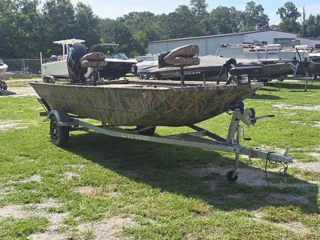 Slide: The Image of A 2025 Lowe RX1760 boat on a trailer in a grassy area. - 4