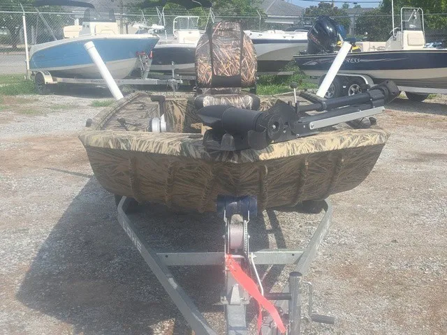 Slide: The Image of A 2022 Lowe Skorpion SS boat with camouflage pattern, parked on a trailer, featuring fishing rod holders. - 4