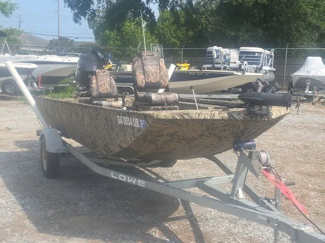 Slide: The Image of A 2022 Lowe Skorpion SS boat on a trailer, featuring camouflage pattern and two seats. - 5