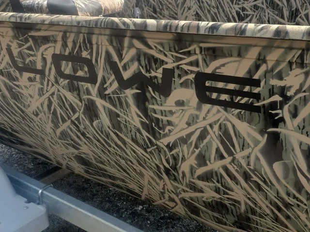 Slide: The Image of Close-up of a boat with camouflage pattern and "Lowe" lettering on the side. - 25