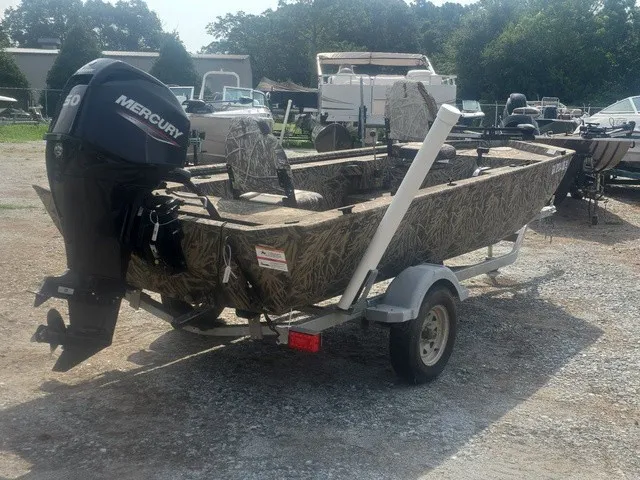 Slide: The Image of A 2022 Lowe Skorpion SS boat with a Mercury outboard motor, parked on a trailer. - 6