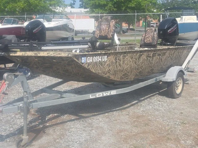 Slide: The Image of A 2022 Lowe Skorpion SS boat on a trailer, featuring camouflage pattern and two outboard motors. - 10