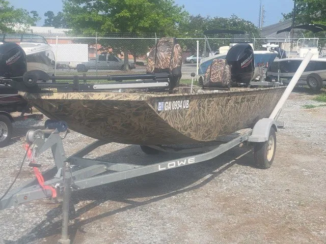 Slide: The Image of A 2022 Lowe Skorpion SS on a trailer, featuring camouflage pattern and outboard motor. - 2