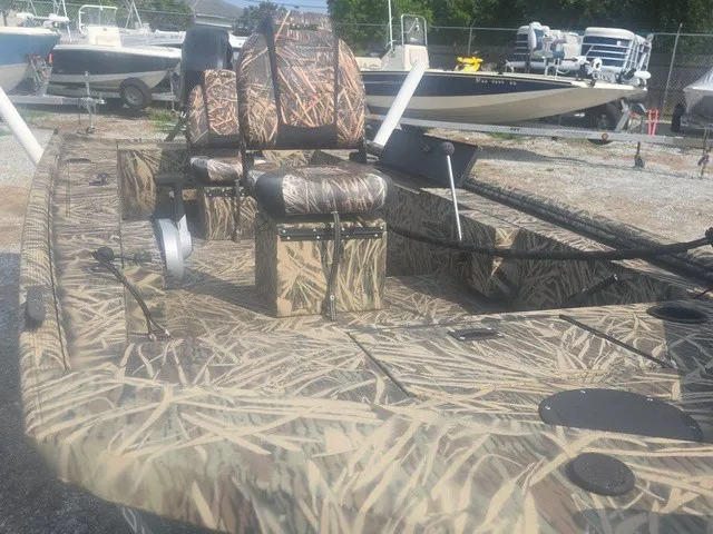 Slide: The Image of A 2022 Lowe Skorpion SS boat with camouflage pattern, featuring cushioned seats and fishing rod holders. - 26