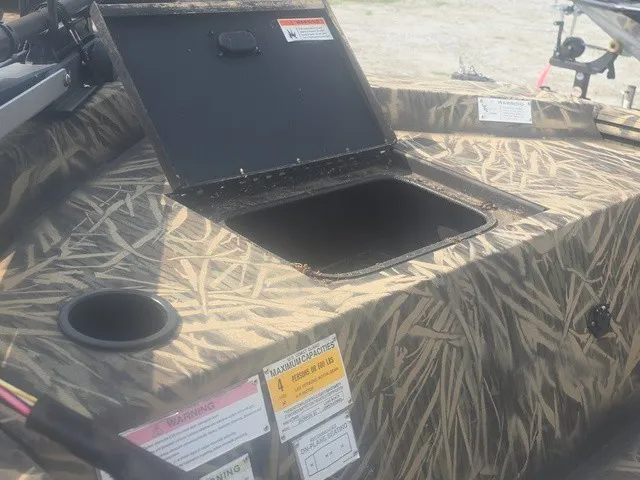 Slide: The Image of A 2022 Lowe Skorpion SS with an open storage compartment on the deck, surrounded by camouflage pattern. - 14