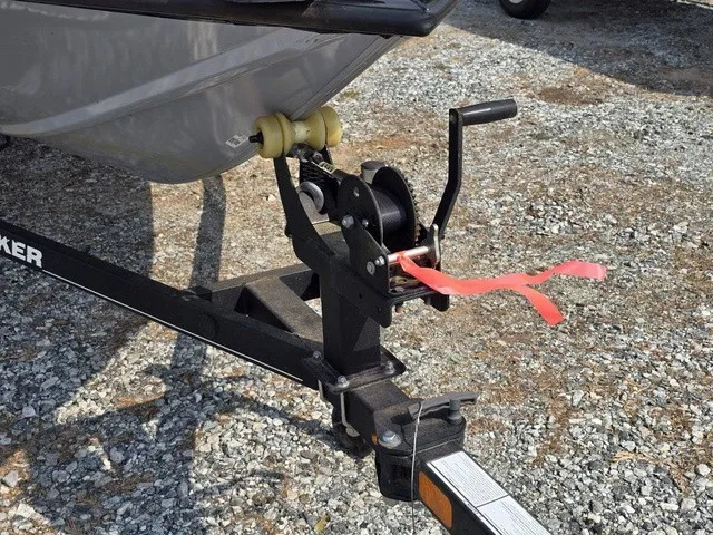 Slide: The Image of A boat trailer with a winch and red strap is parked on a gravel lot. - 3