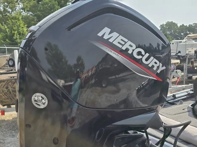 Slide: The Image of Close-up of a Mercury outboard motor on a boat, surrounded by trees and trailers. - 8