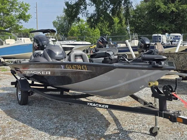 Slide: The Image of A gray 2020 Tracker Pro Team 175 TXW boat on a trailer in a gravel lot. - 4