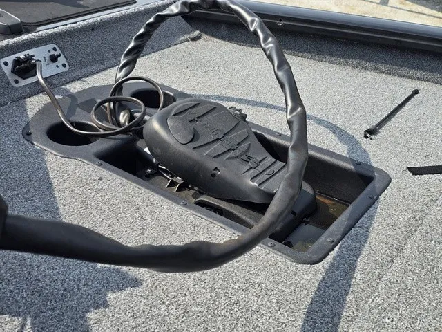 Slide: The Image of Close-up of a boat pedal system with a worn steering wheel and cable on gray flooring. - 17