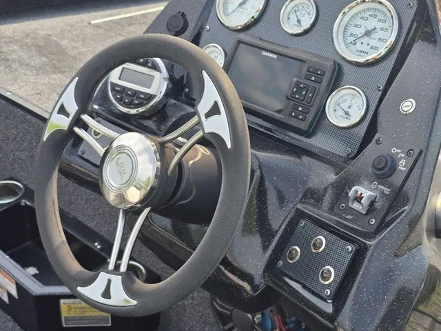 Slide: The Image of The image shows the dashboard of a 2020 Caravelle RAPTOR boat with a steering wheel and gauges. - 25