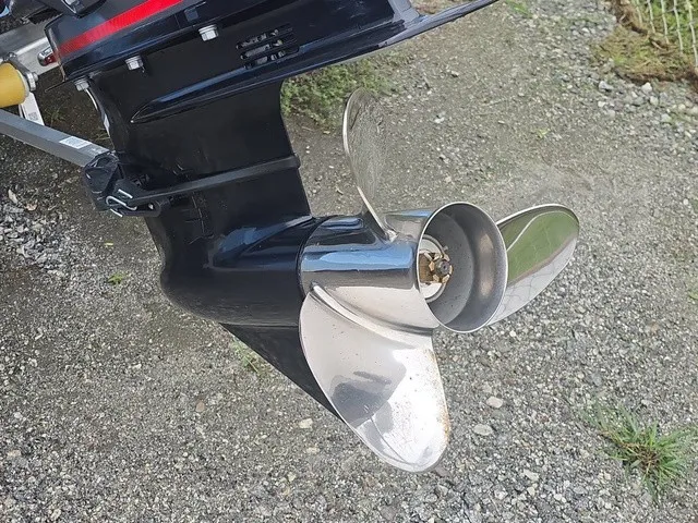 Slide: The Image of Close-up of a shiny propeller on an outboard motor, set on gravel ground. - 19