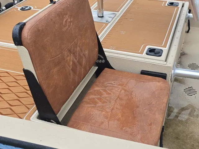 Slide: The Image of A brown leather seat on a boat with textured flooring and metal railing. - 21