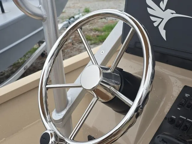 Slide: The Image of The image shows the shiny steering wheel of a 2026 G3 Bay 19 GX boat. - 25