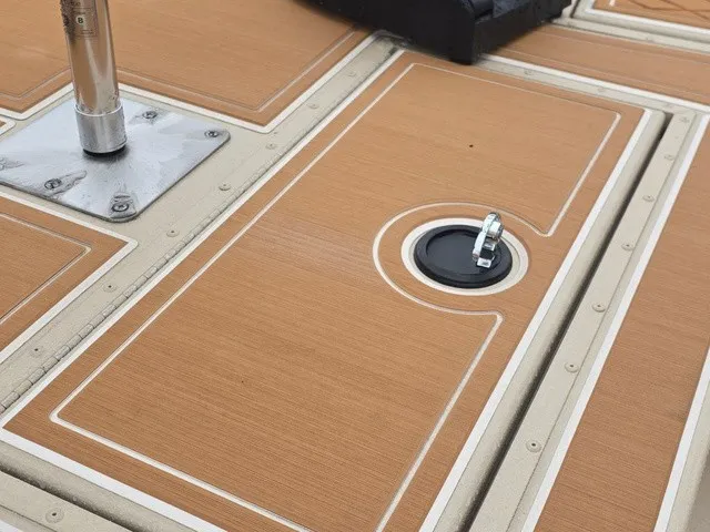 Slide: The Image of Close-up of a G3 Bay 19 GX boat deck with wood-like finish and metal fittings. - 10