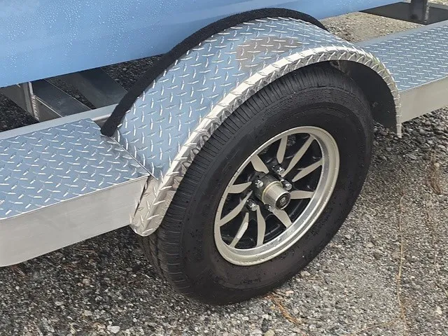 Slide: The Image of Close-up of a boat trailer with a sturdy wheel and diamond-patterned fender. - 12