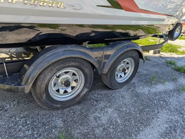 Slide: The Image of A Chaparral 21 SSi boat on a dual-axle trailer with shiny rims. - 13