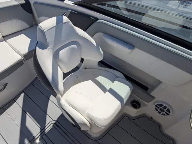 Slide: The Image of A sleek white captain's chair on a modern boat with gray flooring and a speaker. - 23