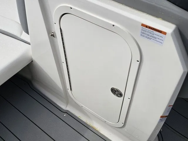 Slide: The Image of A white access door on a boat with gray flooring and warning labels. - 33