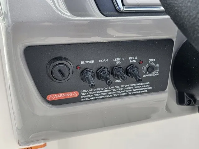 Slide: The Image of Close-up of a Chaparral 23 SSi control panel with various switches and warning labels. - 25