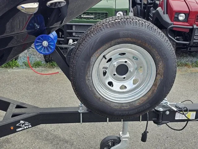Slide: The Image of A spare tire is mounted on a boat trailer parked on a lot. - 11