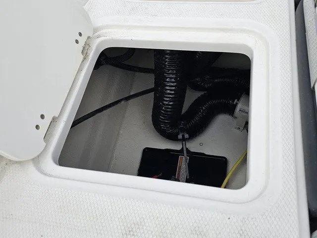 Slide: The Image of An open storage compartment on a boat with visible cables and hoses. - 17