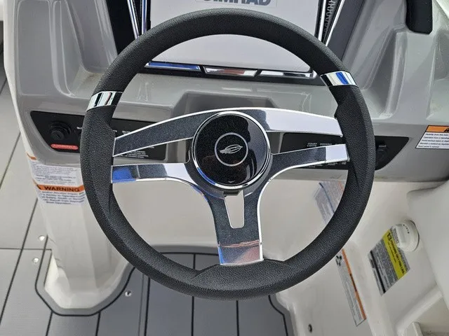 Slide: The Image of The image shows the steering wheel of a Chaparral 23 SSi boat, surrounded by gray flooring. - 23