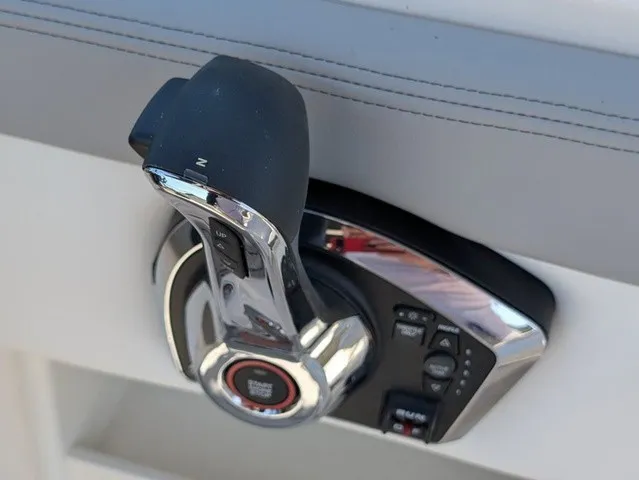 Slide: The Image of Close-up of a modern boat throttle lever with chrome accents and control buttons. - 24