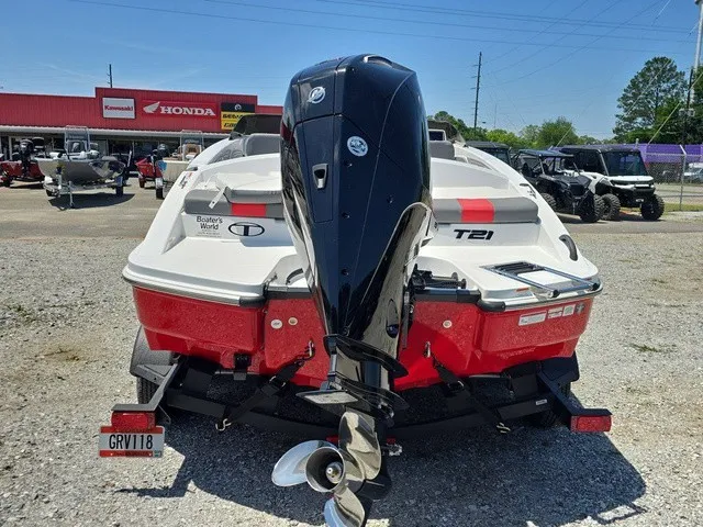 Slide: The Image of A 2026 Tahoe T21 boat on a trailer in front of a store with Honda signs. - 7