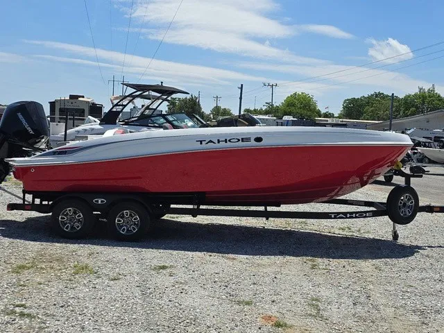 Slide: The Image of A red 2026 Tahoe T21 boat on a trailer in a gravel lot. - 5