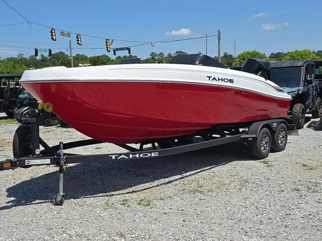 Slide: The Image of A red 2026 Tahoe T21 boat on a trailer in a gravel lot. - 2