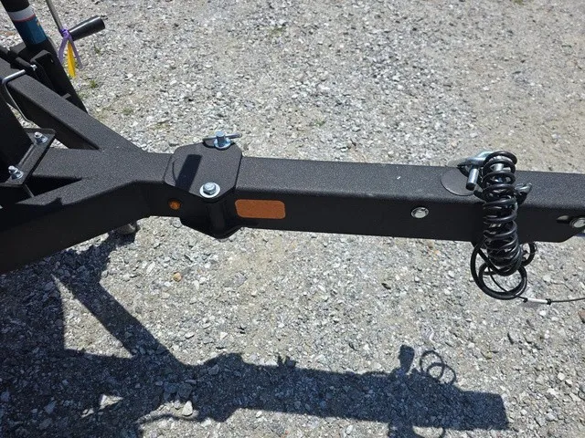Slide: The Image of Close-up of a boat trailer on gravel. The trailer features a black, sturdy construction. - 32