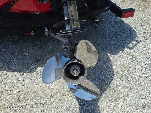 Slide: The Image of Close-up of a shiny propeller on a boat, resting on a gravel surface. - 9