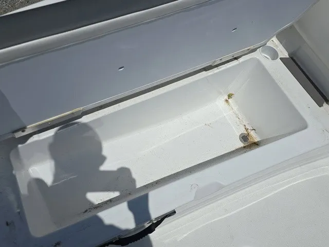 Slide: The Image of An open storage compartment on a boat with a drain hole at the bottom. - 16