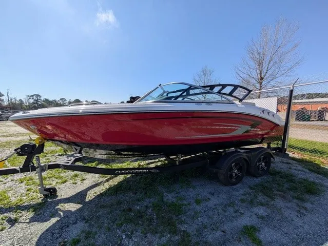 Slide: The Image of A red 2023 Chaparral 21 SSi boat on a trailer in a gravel lot. - 9