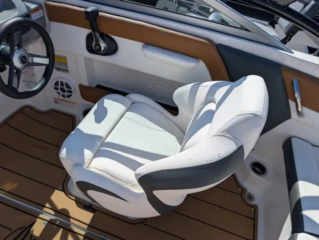 Slide: The Image of The image shows the helm of a 2023 Chaparral 21 SSi with a white seat and brown accents. - 31